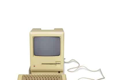 Vintage Apple Macintosh computer with keyboard and mouse.