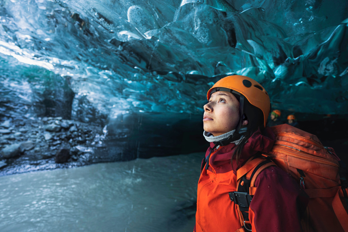 A girl stunned by the beauty of an ice cave in Breiðamerkurjökull, a glacier in Iceland