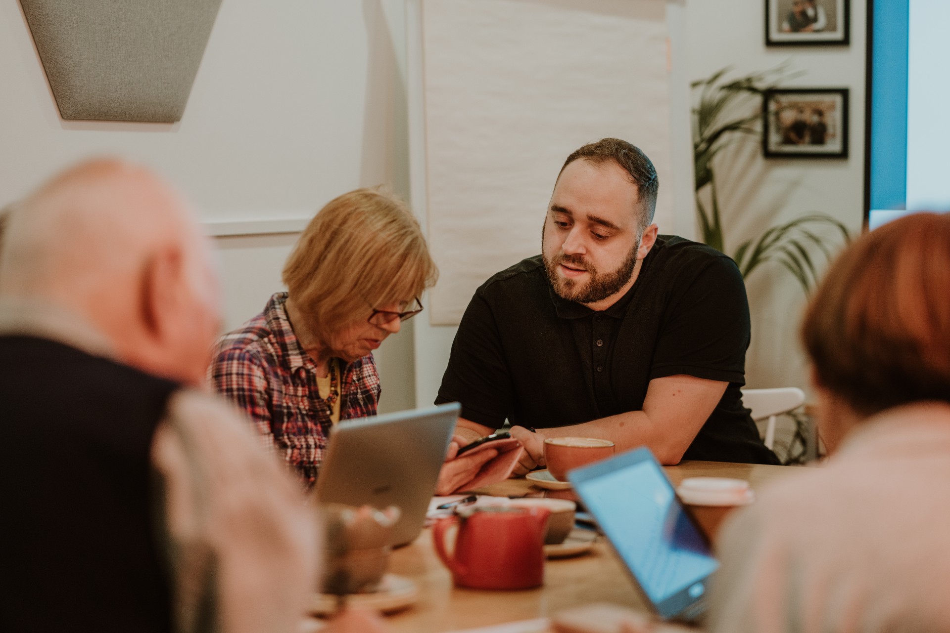 James Wilson, Senior Digital Inclusion Officer at Starting Point supporting learners in one of four weekly drop-in sessions in the community room at the coffee shop.