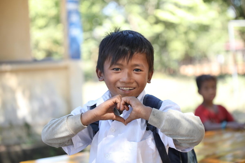 Little boy makes shape of heart with his hands