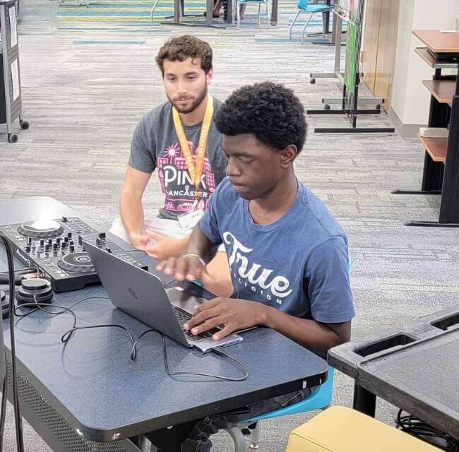 Adult Volunteer Instructing Teen On Audio Equipment At Martin Library