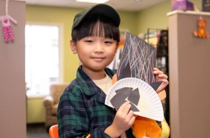 Boy Holding Up Paper Craft