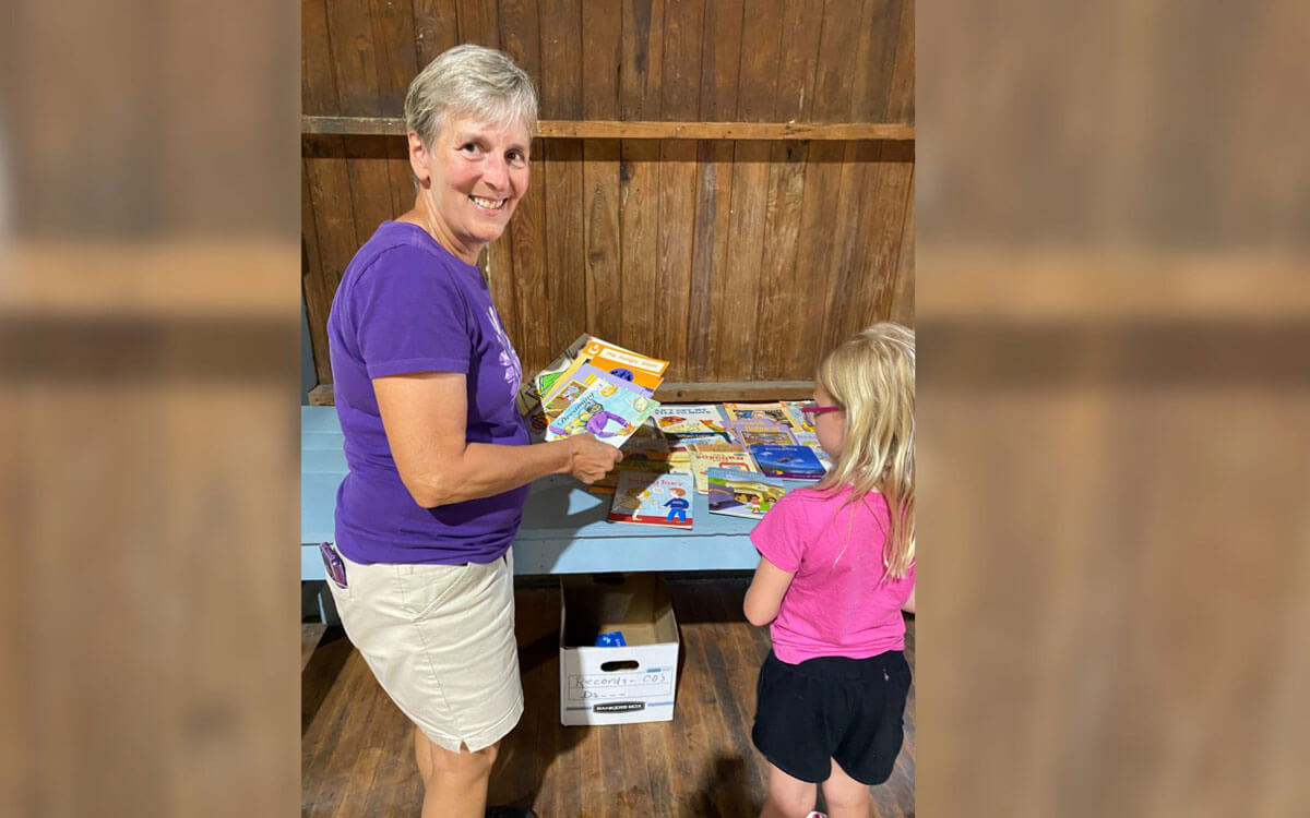 Dover Library Friends President Handing Out Books To Child