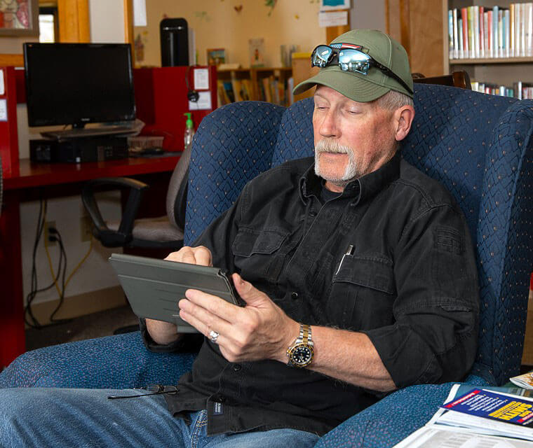 Man Using Tablet Accessing Digital Library Services