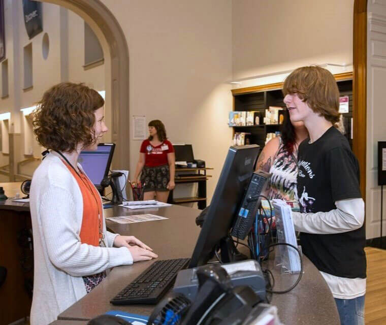 Staff Assisting Teen Answering Questions